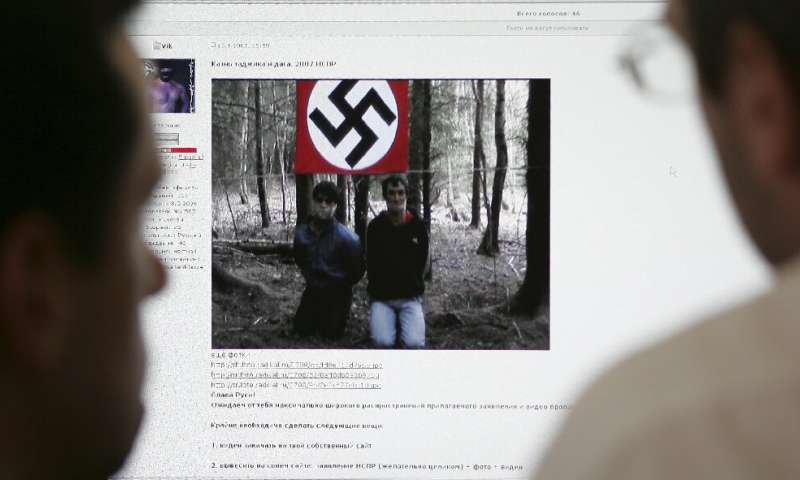 Deux hommes regardent le site Web du Forum national des socialistes slaves unis sur un ordinateur à Moscou en 2007, qui cont