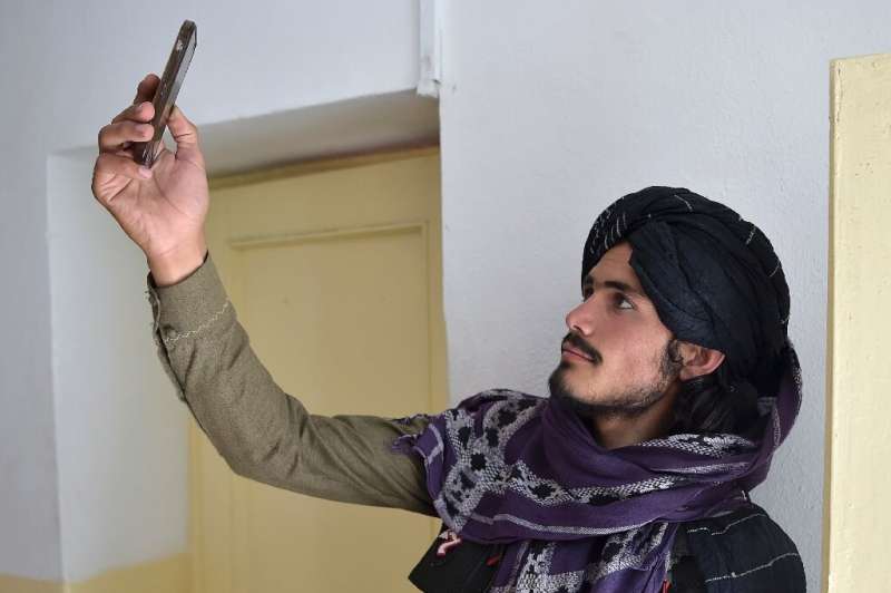 Un combattant taliban recherche un signal réseau dans la province de Ghazni