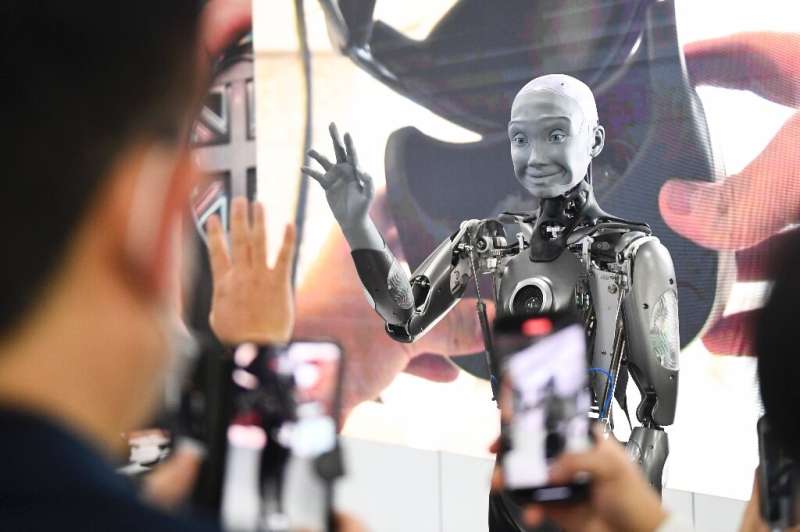 Les participants prennent des photos et interagissent avec le robot humanoïde Engineered Arts Ameca doté de l'intelligence artificielle car il est demonst