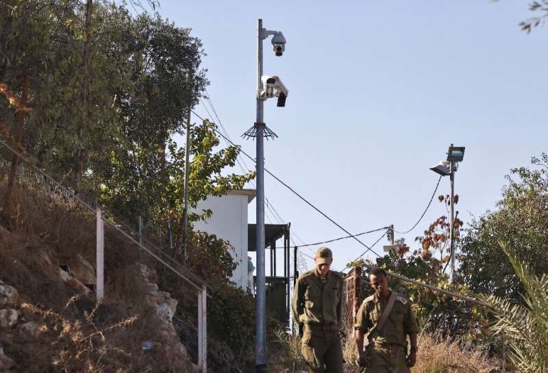 Sur cette photo d'archive prise le 9 novembre 2021, des soldats israéliens passent devant des caméras de surveillance dans la ville palestinienne en feu.
