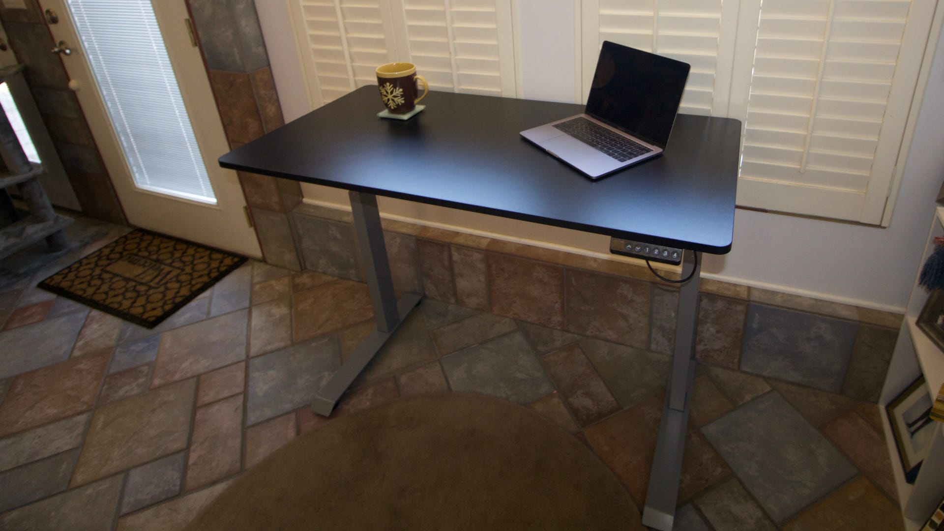 Bureau Victor High Rise avec un ordinateur portable et une tasse à café sur la surface.