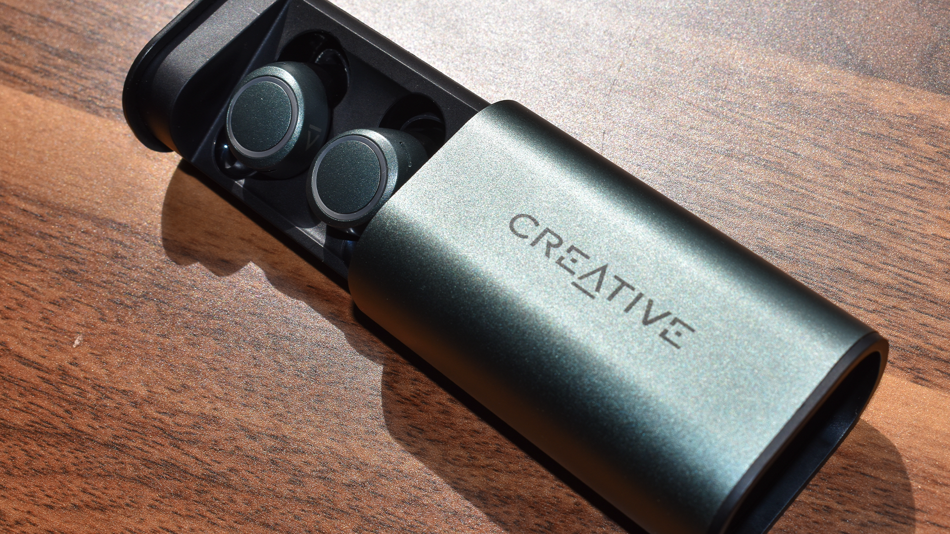 Les Creative Outlier Air V3s dans leur étui. Le tiroir extractible est sorti pour laisser apparaître les écouteurs.